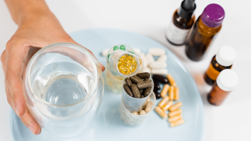 Hand houdt glas water vast naar voedingssupplementen