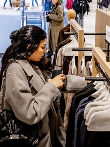 Vrouw zoekt in kledingrek in een winkel van de ZARA 