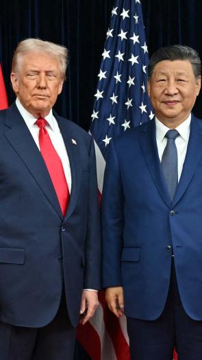Amerikaanse president Donald Trump en Chinese president Xi Jinping poseren samen voor een foto met de Amerikaanse en Chinese vlaggen op de achtergrond.