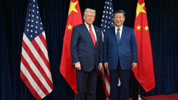 Amerikaanse president Donald Trump en Chinese president Xi Jinping poseren samen voor een foto met de Amerikaanse en Chinese vlaggen op de achtergrond.