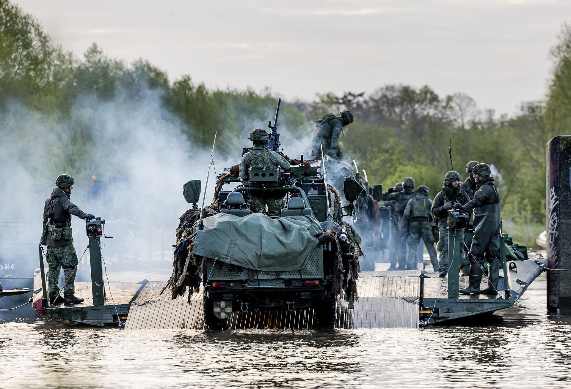 Een gepantserd voertuig steekt een rivier over.