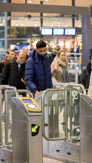 Groep mensen checkt in bij NS-poortjes