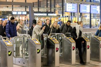 Groep mensen checkt in bij NS-poortjes