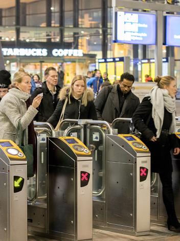 Groep mensen checkt in bij NS-poortjes