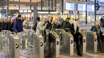 Groep mensen checkt in bij NS-poortjes