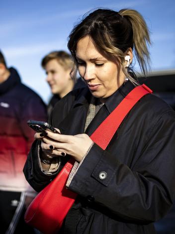 Vrouw loopt op straat maar kijkt naar smartphone