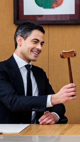 Oud-premier Dick Schoof draagt de symbolische hamer van het premierschap over aan Rob Jetten. Ze zitten samen aan een tafel.