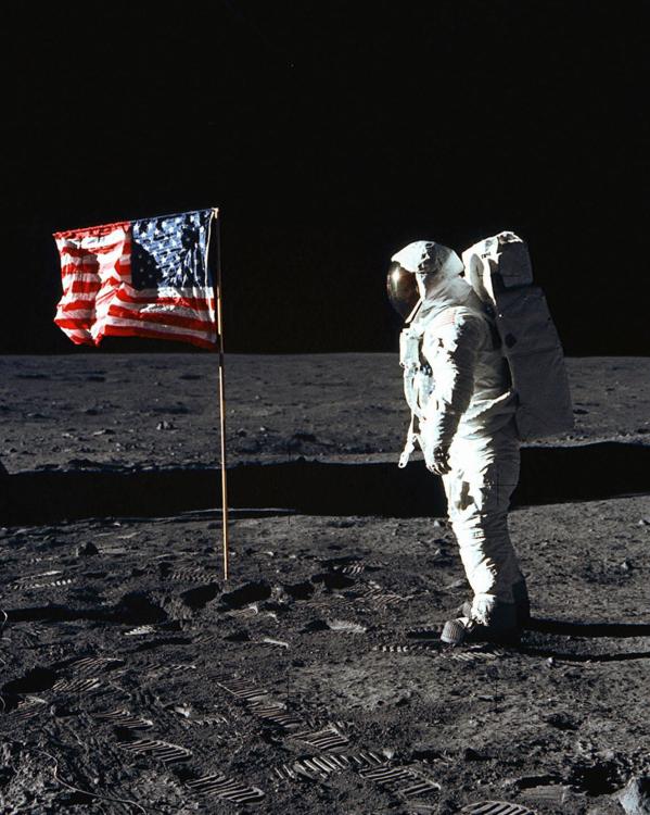 De Amerikaanse astronaut Edwin E. Aldrin jr. op de maan in 1969, naast een Amerikaanse vlag.