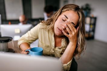 Vrouw wrijft over haar voorhoofd omdat ze overprikkeld is.