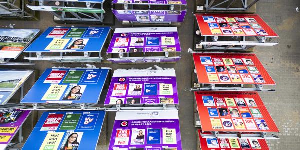 Rijen met verkiezingsborden waar verschillende partijposters op gedrukt staan van verschillende gemeenten