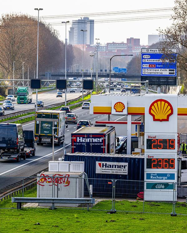 Tankstation van Shell met prijzen per liter langs een drukke snelweg