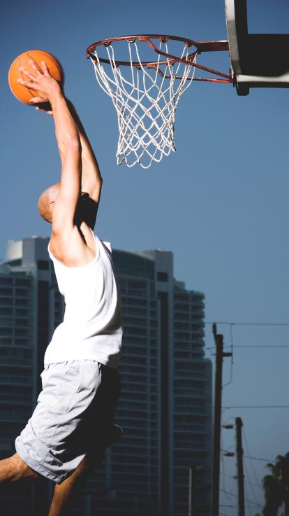 Een man springt om te scoren met een basketbal 