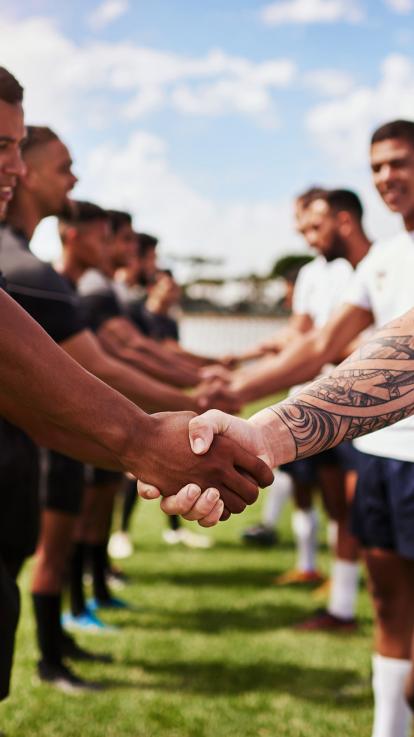 Twee verschillende teams schudden elkaar de hand