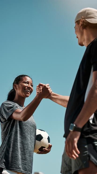 Twee sporters geven elkaar een high five 
