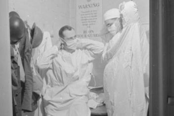 Twee legerartsen binden mondkapjes om in 1941