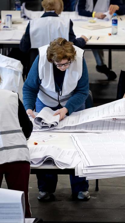 Een vrijwilliger is stemmen aan het tellen tijdens de gemeenteraadsverkiezingen.