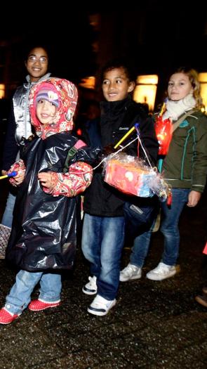 Kinderen gaan met lampions over straat 