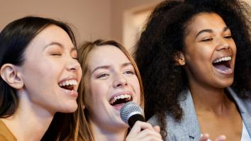 Drie vrouwen zingen samen terwijl ze een microfoon vasthouden 
