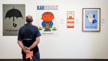 Een man staat in het Rijksmuseum te kijken naar stukken van Dick Bruna