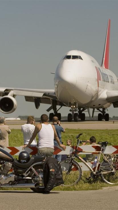 Groep vliegtuigspotters kijken naar de neus van een vliegtuig