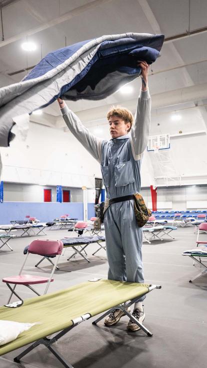 Een vrijwilliger maakt een bed op voor daklozen tijdens stevige vorst.