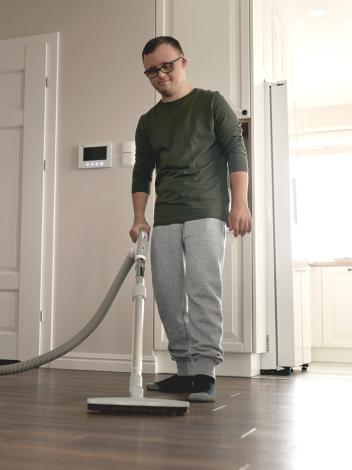 Een man stofzuigt de woonkamer