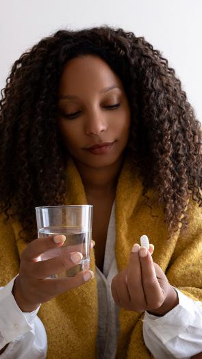 Vrouw neemt een pil met water 