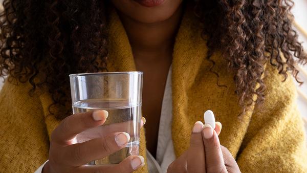 Vrouw neemt een pil met water 