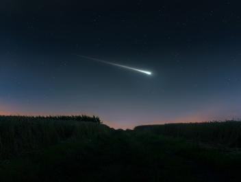 Een meteoriet in de lucht. Sterrenhemel met lichtgevende bal met lichtstreep erachteraan