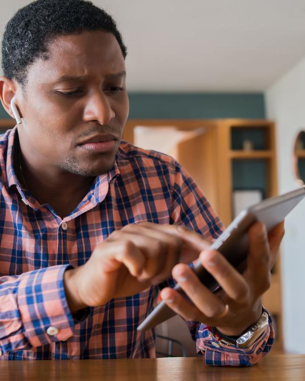 iemand kijkt een beetje verward naar iets op zijn tablet