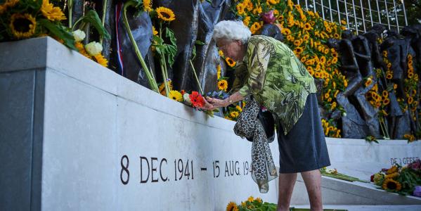 Een vrouw legt een bloem neer bij het herdenkingsmonument voor de oorlogsslachtoffers in Nederlands-Indië