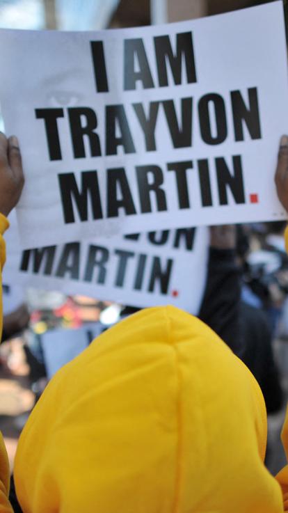 Handen houden een bord vast tijdens protest met de tekst: I am Trayvon Martin. 