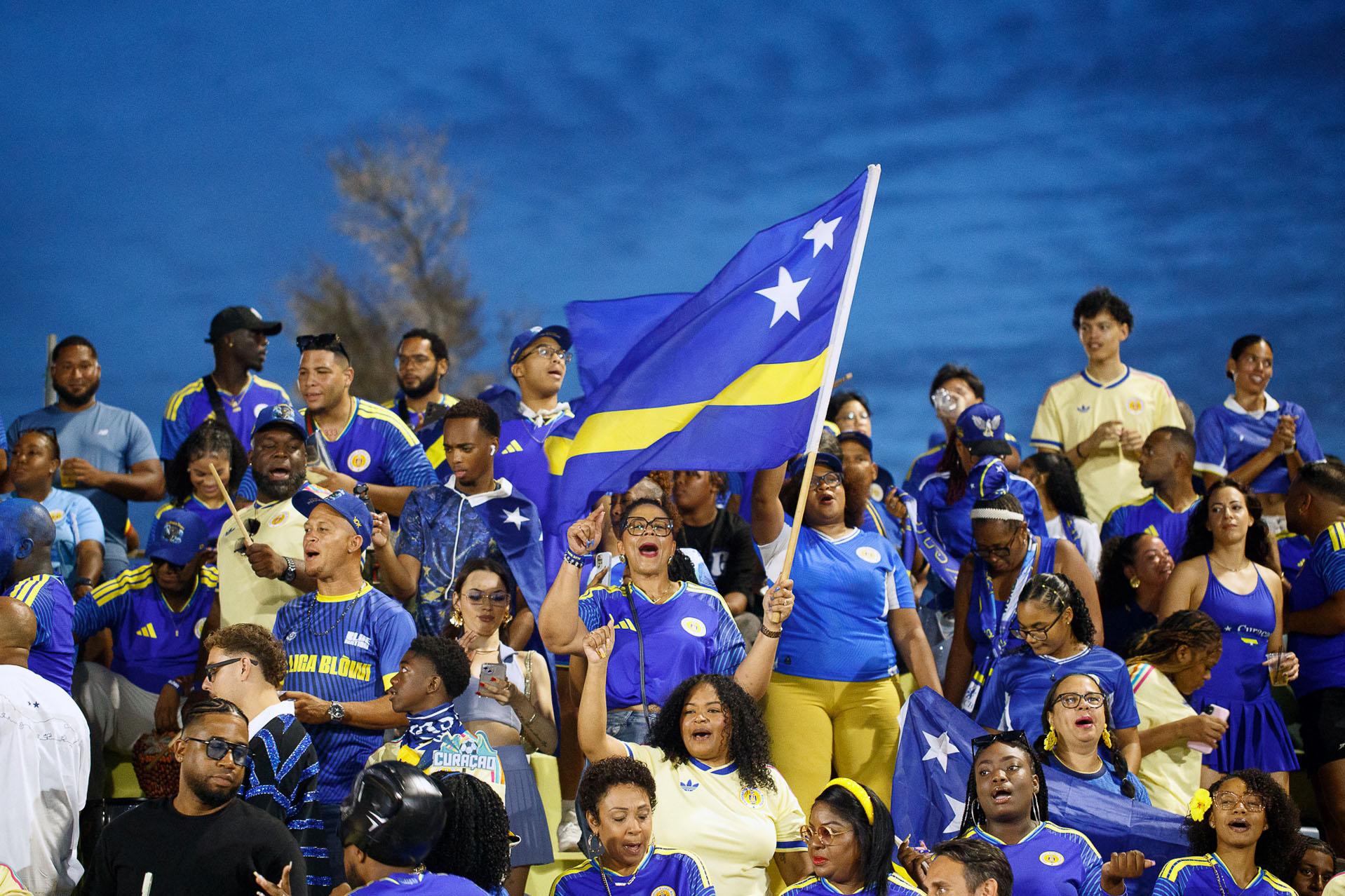 Een groep Curaçao supporters met vlag in aanloop naar het WK