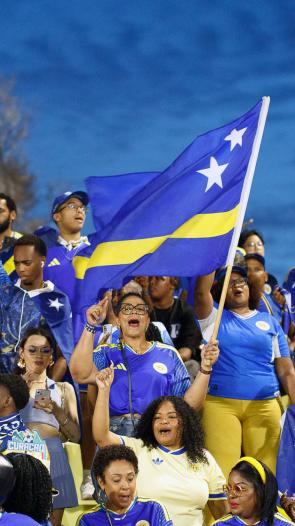 Een groep Curaçao supporters met vlag in aanloop naar het WK