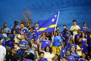 Een groep Curaçao supporters met vlag in aanloop naar het WK