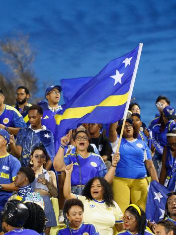 Een groep Curaçao supporters met vlag in aanloop naar het WK