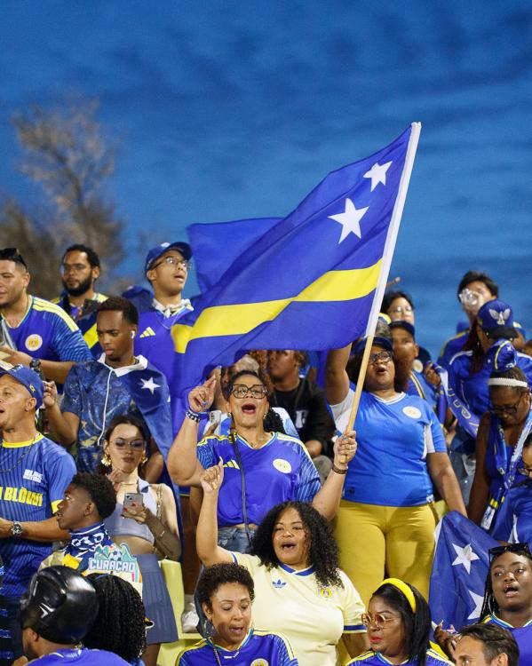Een groep Curaçao supporters met vlag in aanloop naar het WK