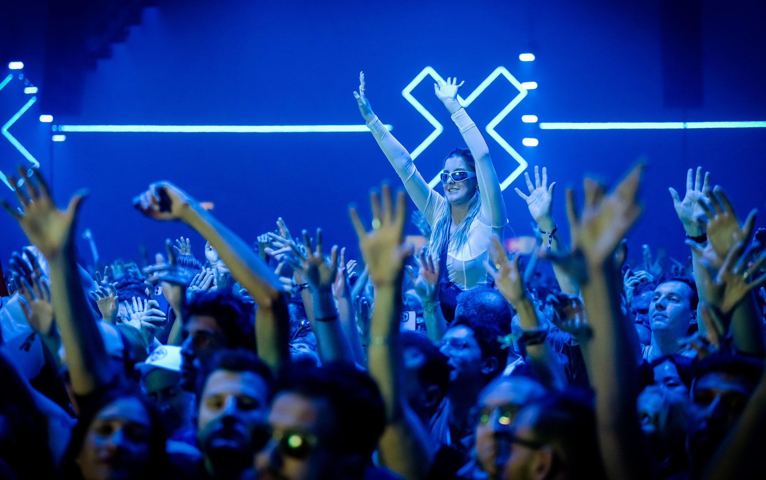 Bezoekers van het Amsterdam Dance Event met hun handen in de lucht