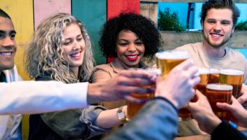 Vrienden proosten lachend met glazen bier 