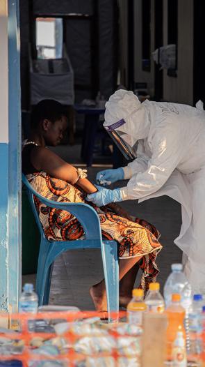 Ebola patient wordt verzorgd door man in beschermende kleding en masker