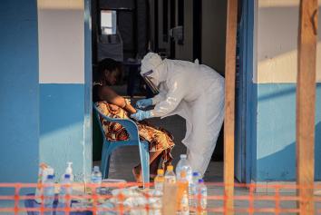 Ebola patient wordt verzorgd door man in beschermende kleding en masker