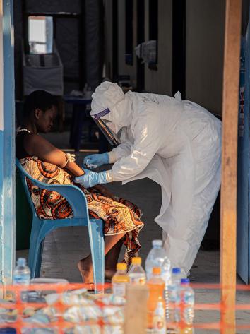 Ebola patient wordt verzorgd door man in beschermende kleding en masker
