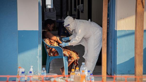 Ebola patient wordt verzorgd door man in beschermende kleding en masker