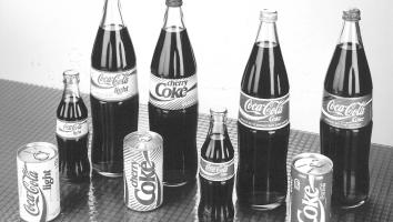 Zwart-wit foto van oude coca-cola flessen en blikjes