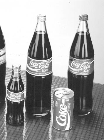 Zwart-wit foto van oude coca-cola flessen en blikjes