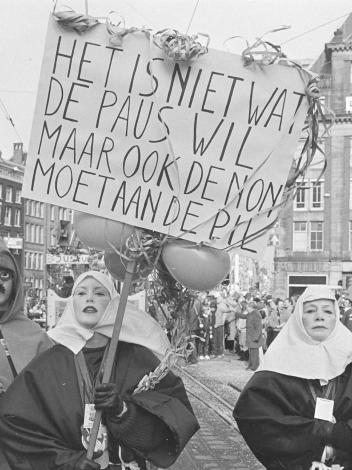 Vrouwen gekleed als nonnen lopen mee met protest met bord met de tekst: Het is niet wat de paus wil, maar ook de non moet aan de pil.