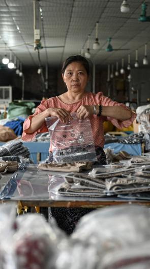 Een vrouw pakt pakketjes in voor Temu in China