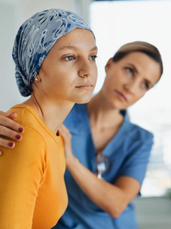 Meisje met haar verlies door kanker zit met haar verpleegster