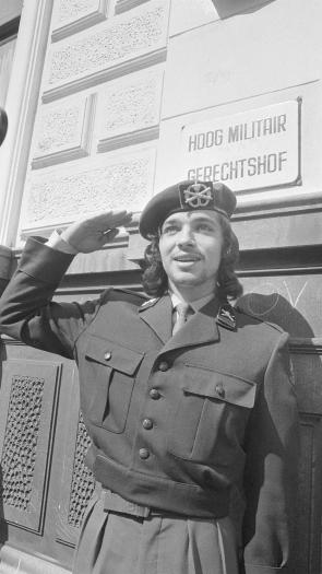 Zwart wit foto van Rinus Wehrmann die met lang haar in uniform salueert