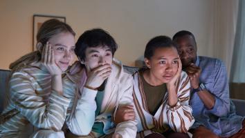 Groep mensen kijkt angstig richting tv